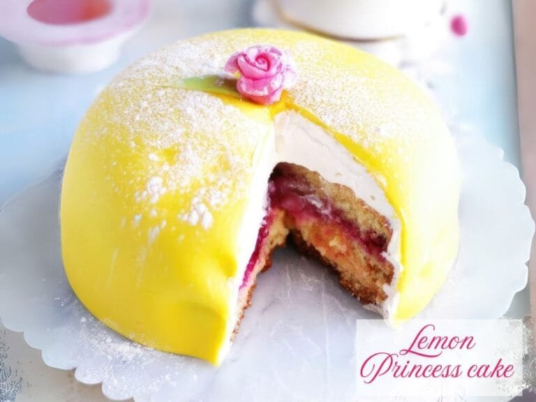A lemon princess cake with a bright yellow marzipan dome, dusted with powdered sugar and topped with a pink rose. A slice is cut out to reveal layers of sponge cake, raspberry jam, lemon curd, and whipped cream.